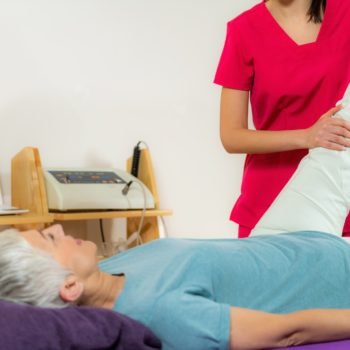 Physical Therapist Working with Leg. Senior Woman
