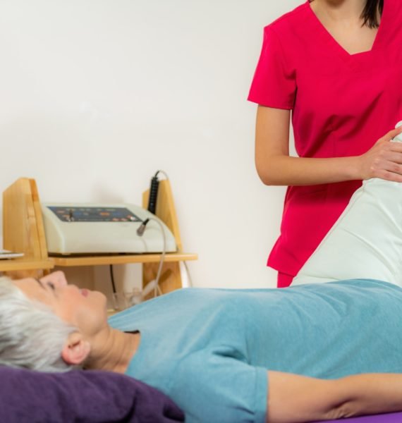 Physical Therapist Working with Leg. Senior Woman